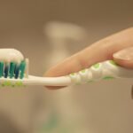 a person is holding a toothbrush with toothpaste on it