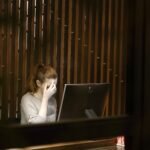 a woman sitting in front of a laptop computer