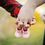 couple holding hands with boots at daytime